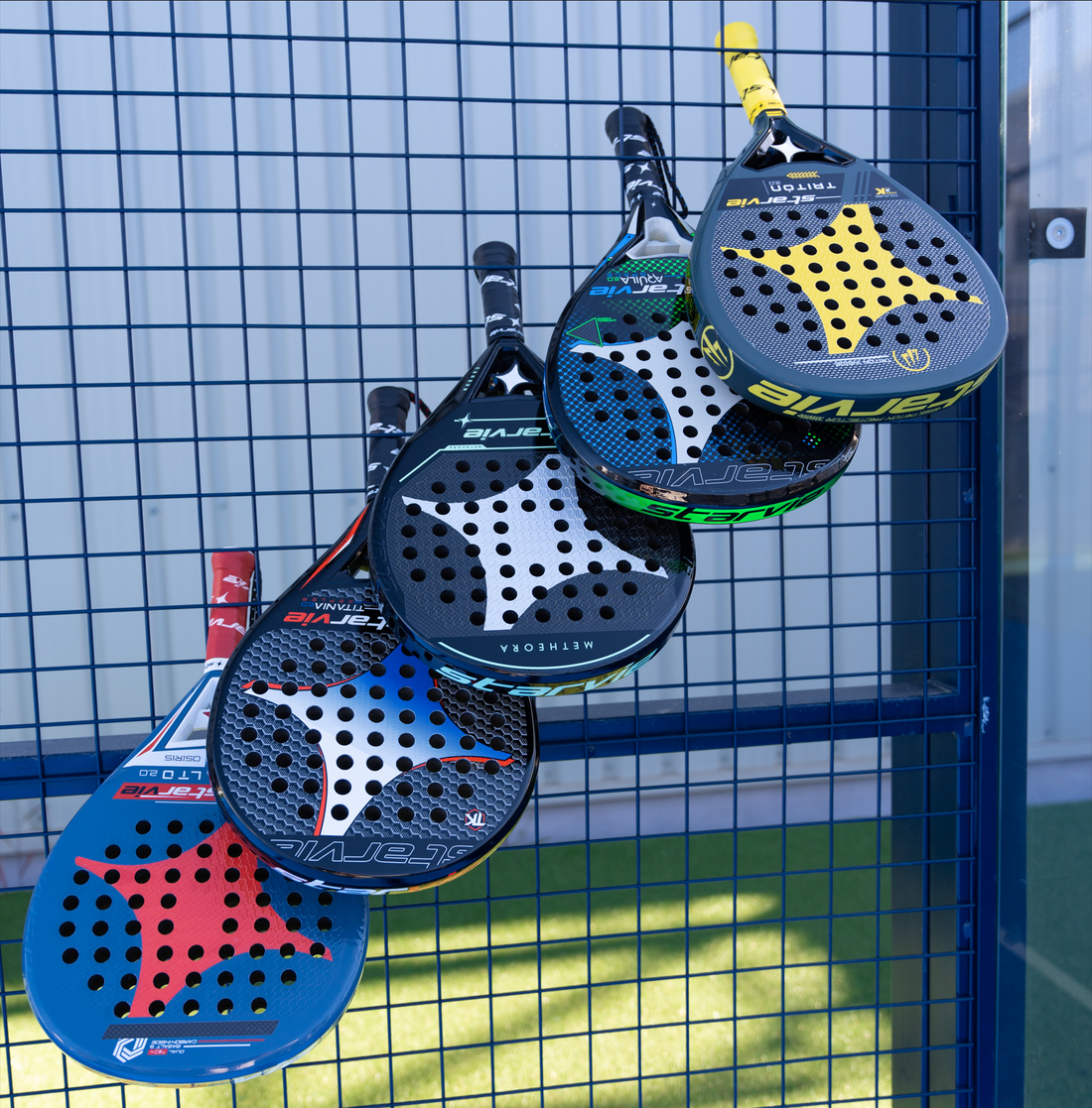 Picture of five colored, Starvie Padel Rackets on Padel Court