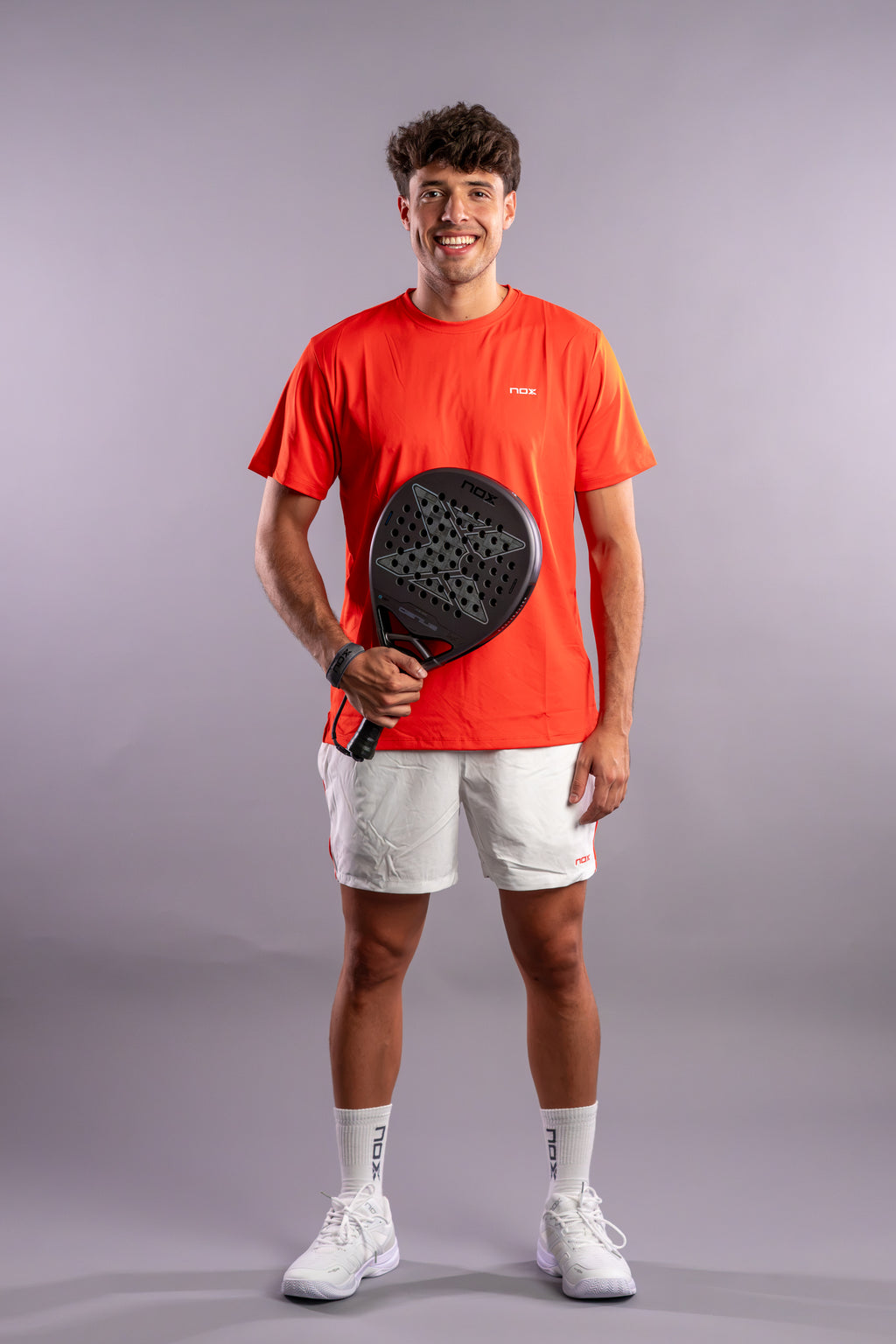 Agustín Tapia smiling while holding the NOX Genius 18k Alum (2027) padel racket available in New Zealand from ThePadelShop NZ